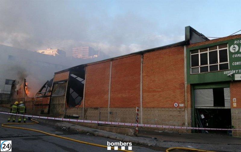 Bomberos trabajan arduamente para extinguir un incendio en una nave de Montcada i Reixach, Barcelona